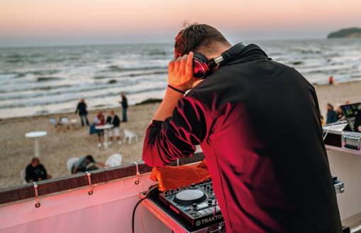 Ein DJ an den Turntables bei der Saisonabschluss-Party am Strand von Binz auf Rügen inklusive einem atemberaubenden Feuerwerk.