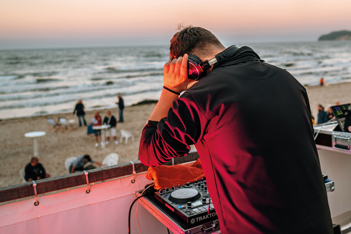 Ein DJ an den Turntables bei der Saisonabschluss-Party am Strand von Binz auf Rügen inklusive einem atemberaubenden Feuerwerk.