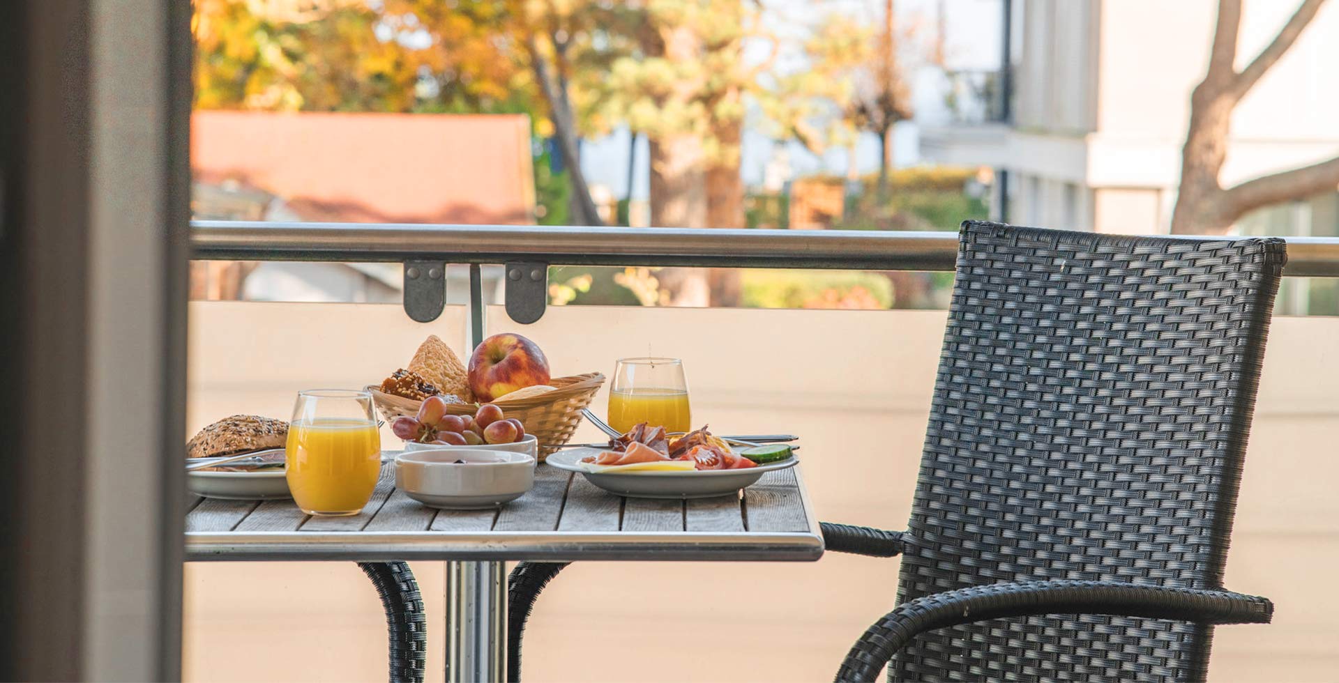 Frisches Frühstück mit Saft, Brötchen und Obst auf dem Balkon der Arkona Strandresidenzen im Ostseeurlaub in Binz